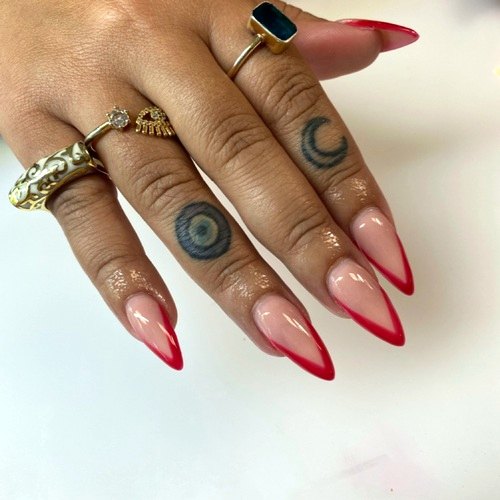 Almond nails with red French tips and rings